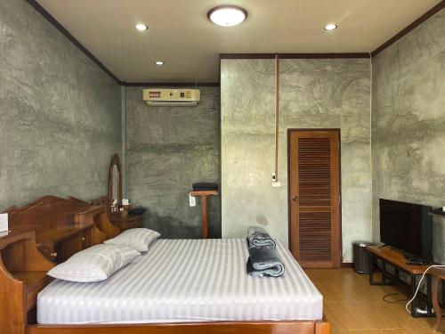 a bedroom with a bed and a television in it at Yaowarate Sport Club and Resort ไร่เยาวเรศ in Ban Mae Ho Phra