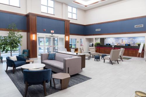 a waiting room with couches and tables and chairs at La Quinta by Wyndham Bannockburn-Deerfield in Bannockburn