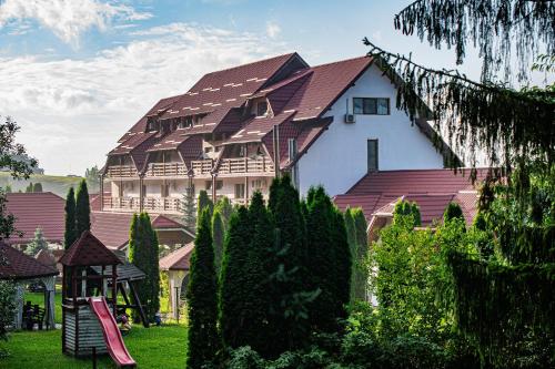 a large house with a playground in front of it at Q Resort and Spa in Săcele