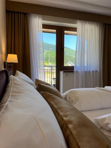 a hotel room with two beds and a window at Penzión JANÍK JASNÁ in Belá