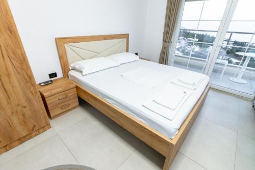 a bedroom with a bed and a large window at Kotarja Apartments in Dhërmi