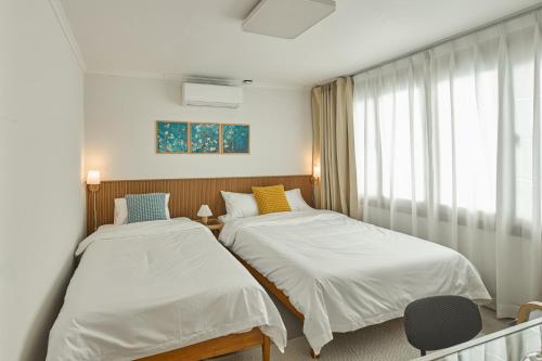 a room with two beds and a window at Banwoldang Stn 3min, 2F 4pm & 3F 8pm Check-in, Table for 6, Hotel bedding, Luggage Storage in Daegu