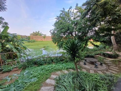a garden with a palm tree and a pond at Homestay 5 Sach in Hue