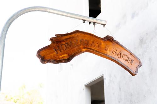 a sign that reads home school hanging on a wall at Homestay 5 Sach in Hue