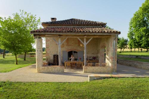a pavilion in a park with a person in it at Chambre tout confort à l'Héritier - au coeur du Tarn in Marzens