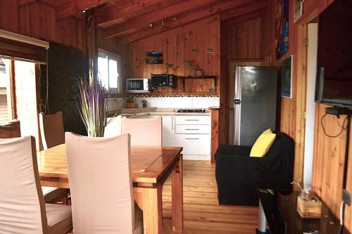 a kitchen and dining room with a table and chairs at Altos de Pichilemu in Pichilemu