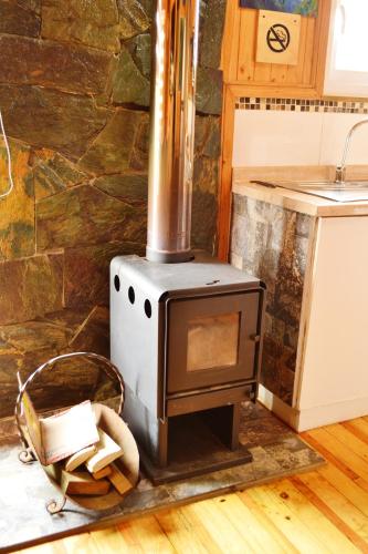 a wood stove in a kitchen with a counter at Altos de Pichilemu in Pichilemu