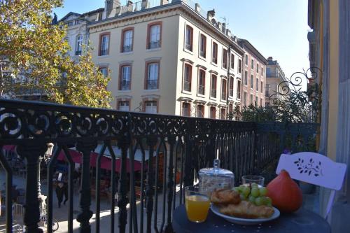 une table avec une assiette de fruits sur un balcon dans l'établissement La Vue de Manuel, à Carcassonne