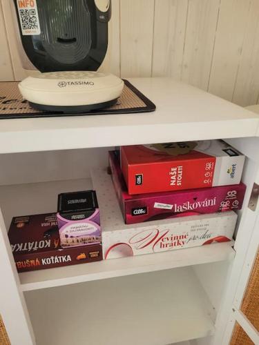 a shelf with books and a plate and a microwave at Domeček pohoda maringotka Máňa in Liberec