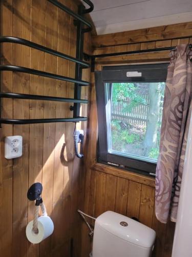 a small bathroom with a toilet and a window at Domeček pohoda maringotka Máňa in Liberec