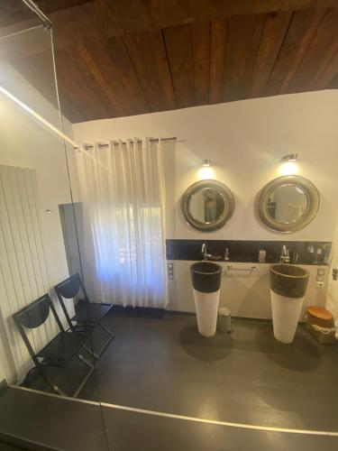 La salle de bains est pourvue de 2 lavabos et de 2 miroirs sur le mur. dans l'établissement Bergerie de Peymeyan, à Saint-Paul-en-Forêt