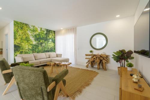 ein Wohnzimmer mit einer Couch und einem Tisch in der Unterkunft Villa Lola in Mariquiteira