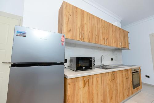 a kitchen with a refrigerator and a microwave at Kotarja Apartments in Dhërmi