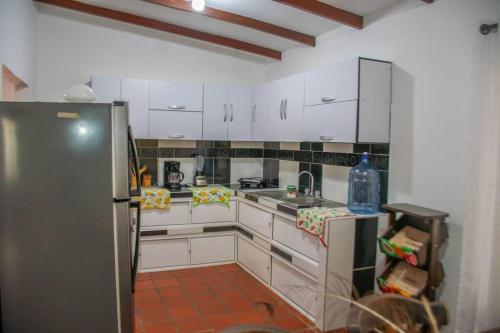 a kitchen with white cabinets and a stainless steel refrigerator at Finca Las Gaviotas - Mulaló, Yumbo in Yumbo