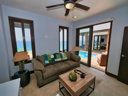 a living room with a couch and a table at Eagle Ray - A Luxurious Waterfront Villa, in Gibson Bight