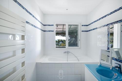 une salle de bain blanche avec une baignoire et un lavabo dans l'établissement Somptueuse Villa l'Oasis By HC, à Carqueiranne