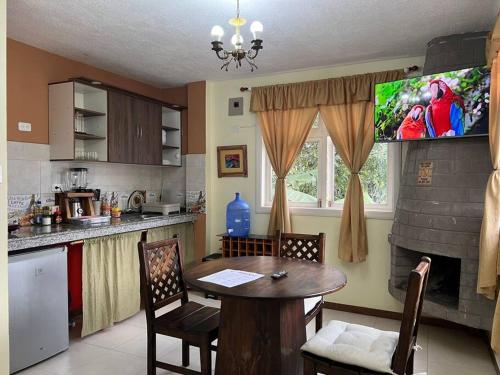 eine Küche mit einem Tisch und einem TV in der Küche in der Unterkunft Charming apartment 2 bedroom 2 bath in Baños