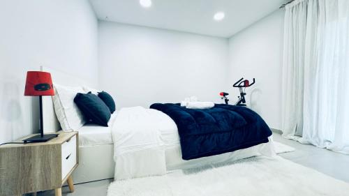 a white bedroom with a bed with a blue blanket at Luminous Luxury House in Pýli