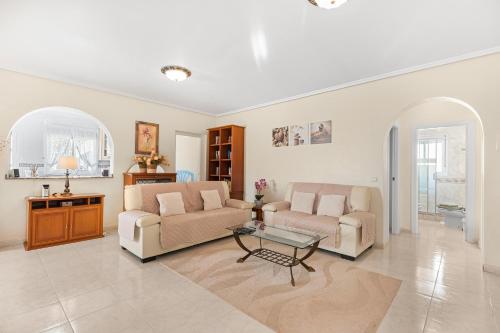 a living room with two couches and a table at Villa Quesada in Rojales