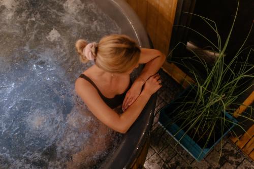 a woman sitting in a bath tub at Dobre Kąty całoroczne domki in Kąty Rybackie