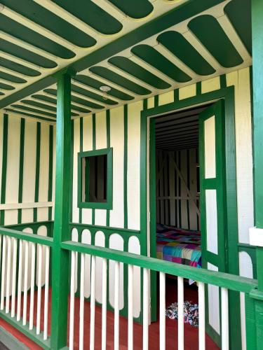 a room with a balcony with green and white stripes at El Agrado Restaurante Cabañas in Líbano