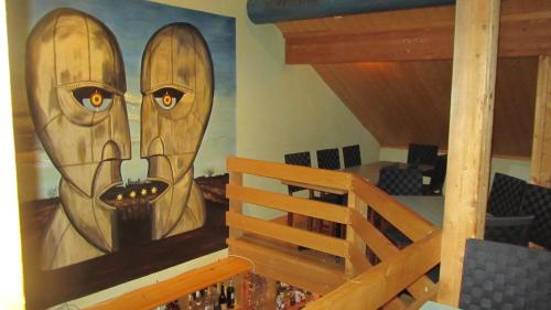 a painting of two faces on the wall of a room at Restaurant Felsenburg in Kandergrund
