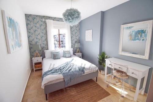 a bedroom with a bed and a desk and a mirror at Piso Amaranta, Frigiliana Modern 2 bedroom, 2 bathroom Apartment with Air conditioning and Pool HansOnHoliday Rentals in Frigiliana