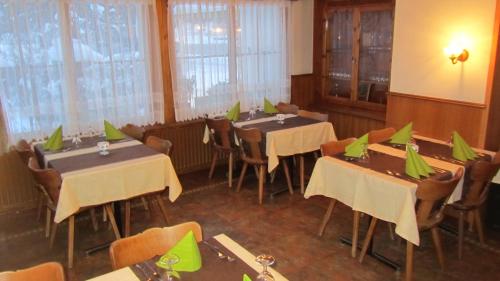 a dining room with tables and chairs with green napkins on them at Restaurant Felsenburg in Kandergrund