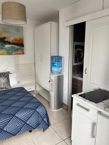 a small bedroom with a bed and a kitchen at Alojamiento PlayaArco in Los Escullos