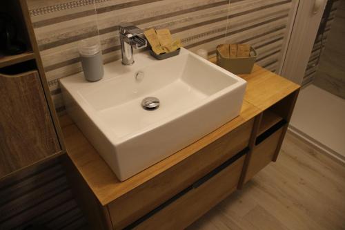 a white sink sitting on a wooden counter in a bathroom at Casa Vacanze Sud e Magia in Castelmezzano