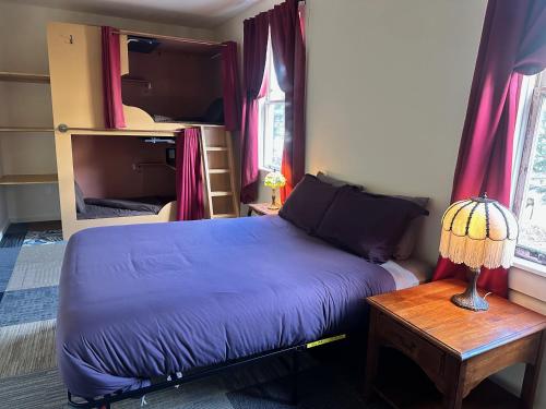 a bedroom with a bed and a table with a lamp at West River House in Truckee