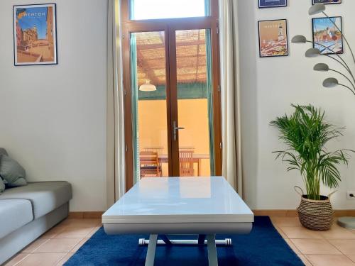 un salon avec une table blanche et un canapé dans l'établissement Appartement terrasse centre,, à Menton