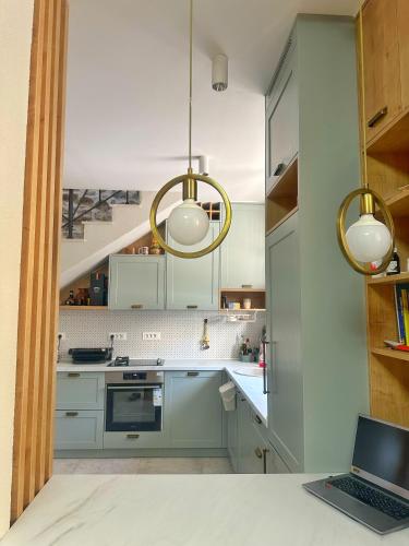 Eine Küche mit blauen Schränken und einem Laptop auf der Arbeitsplatte. in der Unterkunft Pool House Risan in Risan