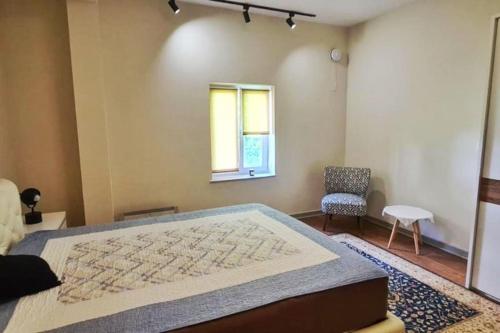 ein Schlafzimmer mit einem großen Bett, einem Fenster und einem Stuhl in der Unterkunft Pool House Risan in Risan