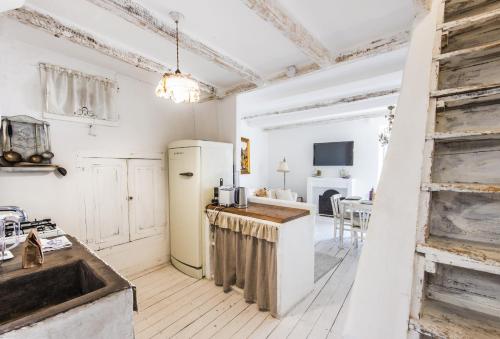 une cuisine avec un réfrigérateur blanc et un évier dans l'établissement Au vieux château, atypique vue mer, à Menton