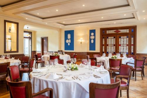 a dining room with white tables and chairs at Hotel Alma Am Anger in Erfurt