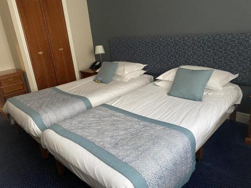 two beds sitting next to each other in a hotel room at Woodbury Park Hotel & Spa in Exeter