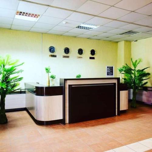 a lobby with two tables and two palm trees at Alatau Hotel in Astana