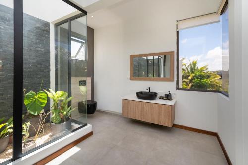 a bathroom with a sink and a large window at Villa Cookie le Coquin, 3 chambre au centre de Grand Baie, jacuzzi in Grand Baie