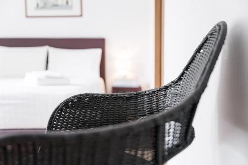 a black chair in a bedroom with a bed at Quinta de São Martinho Visconde do Penedo in Soengas