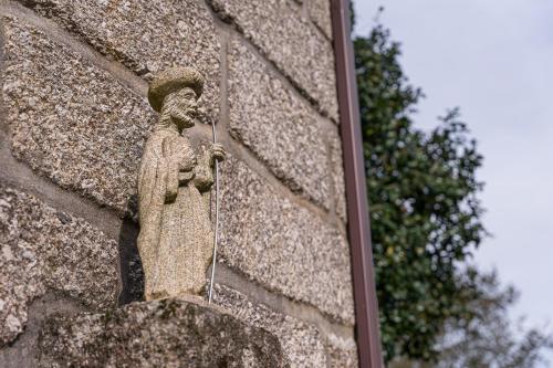 a statue on the side of a brick wall at Quinta de São Martinho Visconde do Penedo in Soengas