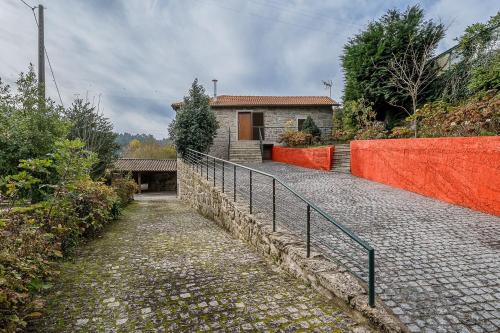 a house with a fence next to a walkway at Quinta de São Martinho Visconde do Penedo in Soengas