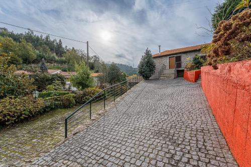 a stone walkway leading up to a house at Quinta de São Martinho Visconde do Penedo in Soengas