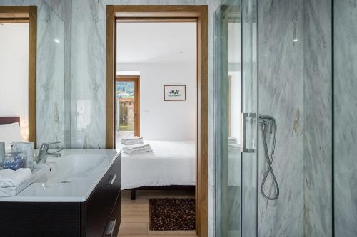 a bathroom with a shower and a sink and a bed at Quinta de São Martinho Visconde do Penedo in Soengas