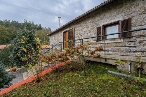 a stone house with a staircase next to a building at Quinta de São Martinho Visconde do Penedo in Soengas