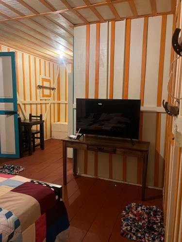 a room with a tv and a table with a bed at El Agrado Restaurante Cabañas in Líbano