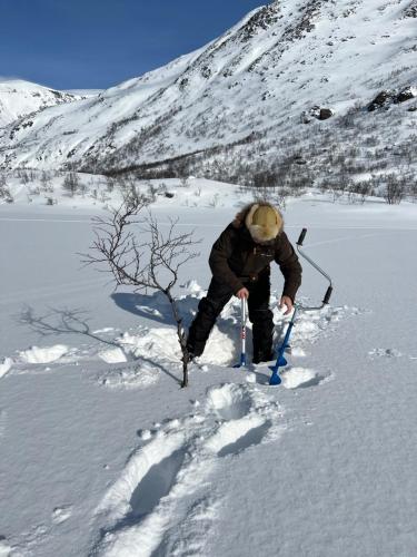 a man is walking through the snow at Bestefarhuset in Hakkstabben