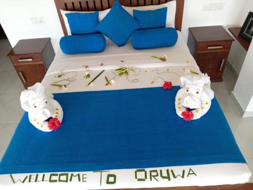 a bed with two hello kitty pillows on it at Oruwa Turtle Beach Villa in Kosgoda