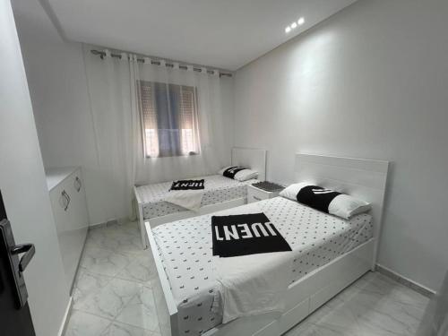 a white room with two beds and a window at Apartment in Al Hoceima in Al Hoceïma