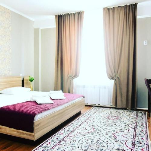 a bedroom with a bed and a large window at Alatau Hotel in Astana